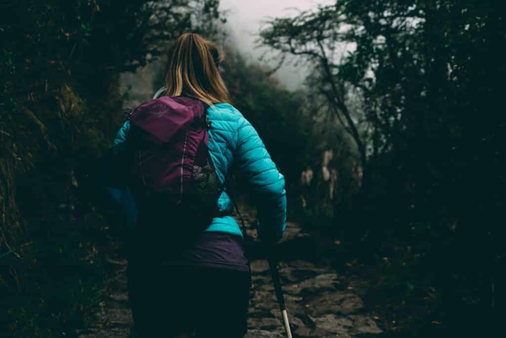 Woman hiking up a misty mountain path