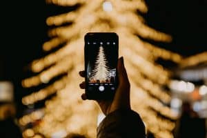 Person photographing a christmas tree with their phone