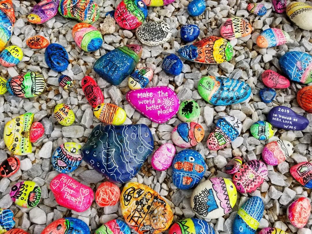Pebbles painted with colourful messages of kindness