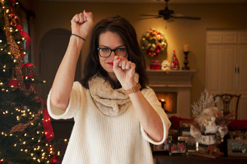 GIF of someone doing charades in front of an Xmas tree