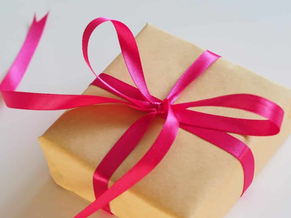 Photo of a wrapped gift with a bright pink ribbon