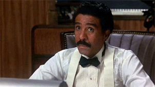 GIF of Richard Pryor making a gesture with his hands suggesting just a little bit