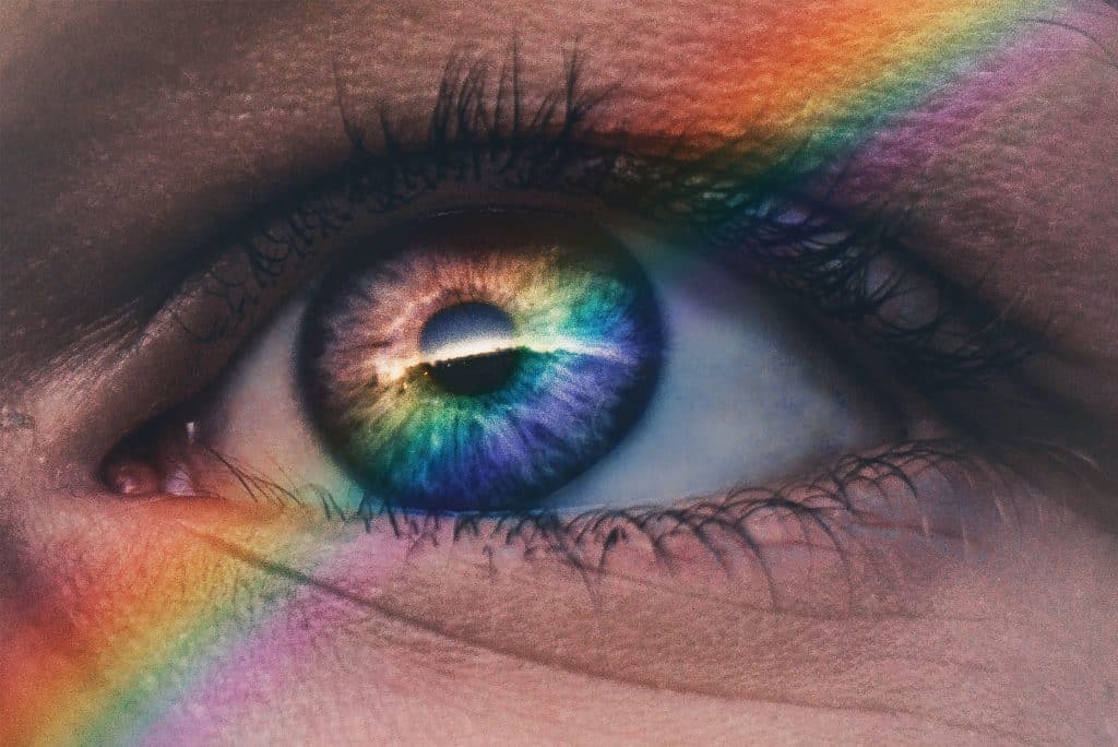 Photo of an eye looking out at a rainbow