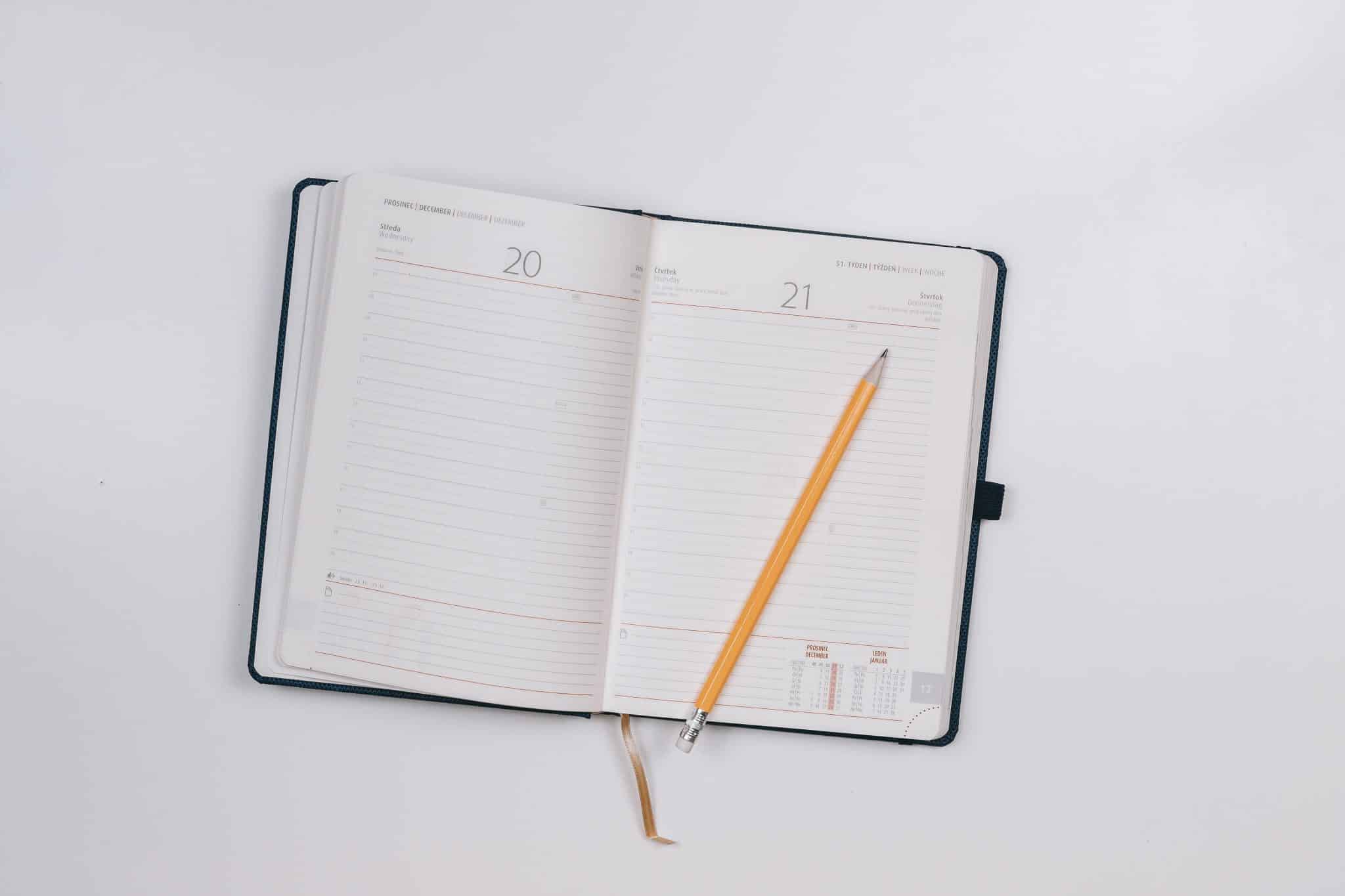 A photo of a blank journal with a pencil sitting on top