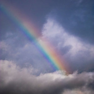 A rainbow breaking through clouds